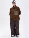 Pantalon de ski ample et fluide pour femme, en polaire sherpa synthétique zippée et genoux renforcés.