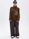 Pantalon de ski ample et fluide pour femme, en polaire sherpa synthétique zippée et genoux renforcés.