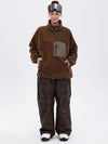 Pantalon de ski ample et fluide pour femme, en polaire sherpa synthétique zippée et genoux renforcés.